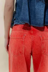 Pantalón de jean de tiro medio y pierna ancha, confeccionado en denim 100% algodón. Diseño con 5 bolsillos y pespuntes a contratono.