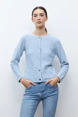 Chaqueta de punto color celeste, con cuello redondo, manga larga y cierre frontal con botones metálicos plateados.