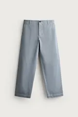 Pantalón chino para hombre de corte relajado, confeccionado en tejido de algodón con efecto lavado en color celeste. Cuenta con bolsillos delanteros, bolsillos traseros de vivo con botón y cierre frontal con cremallera y botón.