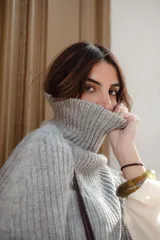 Poncho tejido de lana con cuello alto y diseño de calce relajado, ideal para capas de abrigo.
