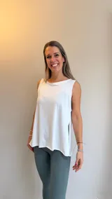 Musculosa blanca de corte holgado con aberturas laterales, confeccionada en tejido suave y respirable.