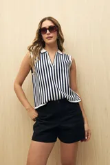 Short de gabardina color beige, de tiro alto y corte recto, con bolsillos laterales y cierre frontal con botón.