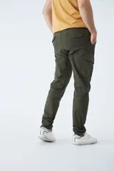 Pantalón cargo de corte slim, color negro, con bolsillos laterales con solapa y botones metálicos. Cuenta con cierre frontal, botón en la cintura y pasacintos.