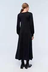 Vestido largo negro con sutiles detalles de lurex azul, escote en V y mangas largas.