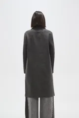 Tapado de corte recto con solapas clásicas y cierre frontal de un botón. Presenta mangas largas y bolsillos laterales integrados.