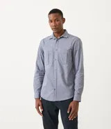 Camisa de manga larga color celeste con textura, cuello camisero, cierre frontal con botones y dos bolsillos de parche en el pecho.