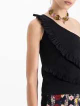 Top negro de un solo hombro con volados en el delantero.