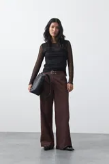 Top de manga larga confeccionado en tejido translúcido con micro textura de puntos, de silueta ajustada y diseño liviano.