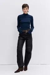 Blusa de punto acanalado en color azul marino, con cuello alto y mangas largas ajustadas.