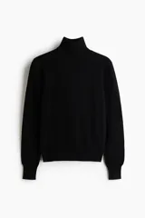 Polera de punto fino color negro, con cuello alto, mangas largas y diseño acanalado en cuello, puños y bajo.