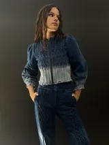 Campera de jean azul con lavado artesanal, entallada y corta hasta la cintura alta. Presenta textura central en el delantero.