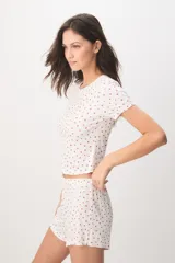 Pijama de viscosa y elastano de color blanco con estampado de fresas, compuesto por una remera de manga corta y cuello redondo, y un short con cintura elástica.