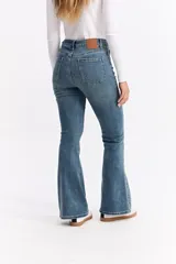 Jean de corte oxford con tiro alto, ajustado hasta la rodilla y con apertura amplia en el bajo. Confeccionado en denim negro con cierre frontal de botón y cremallera.