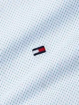 Camisa celeste con micro estampado de puntos, de manga larga y corte regular. Tiene cuello abotonado, cierre con botones y logo de Tommy Hilfiger bordado en el pecho.