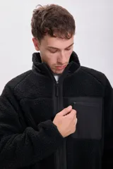 Campera de sherpa color negro con cierre frontal, cuello alto y bolsillo frontal con cierre en contraste.