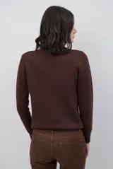Polera de tejido de punto fino en color beige, con cuello alto y mangas largas con puños acanalados.