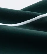 Pantalón recto verde oscuro con cintura elástica y vivos laterales blancos.