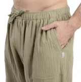 Pantalón de tela verde oliva, corte recto, con cintura elástica ajustable con cordón y bolsillos laterales.