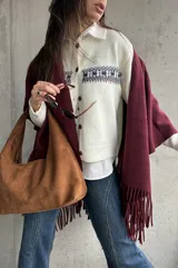 Cardigan de punto color natural con diseño de guarda nórdica en el pecho y cierre frontal con botones marrones.