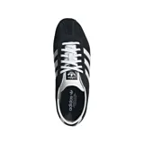 Championes Adidas modelo Tokyo, color negro con las tres rayas distintivas de la marca en blanco y detalles plateados en el talón y la lengüeta. Suela de goma color caramelo.