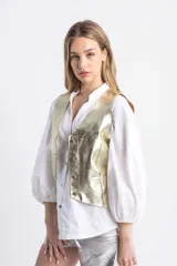 Chaleco sastrero dorado champagne de cuero, con botones metálicos.