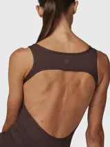 Enterito largo color chocolate, de tirantes, confeccionado en tejido suave y elástico. Presenta espalda abierta y piernas ligeramente anchas.