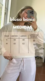 Blusa de lurex color blanco, de tejido suave, con escote redondo y puños en las mangas.