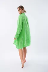 Camisa de lino verde con botones de nácar, corte amplio y largo asimétrico.