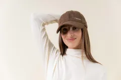 Gorra de diseño clásico con visera curva, confeccionada en material símil gamuza color bordó. Presenta un logo metálico con la palabra Peach en la parte frontal y cuenta con un sistema de ajuste posterior.
