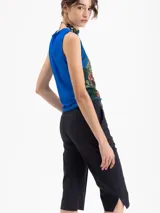 Top sin mangas de corte ajustado, color azul vibrante, con estampado artístico que incluye cerezas, columnas y elementos florales en tonos verdes, amarillos y rojos.