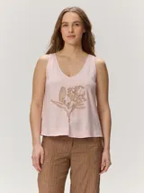 Musculosa de algodón color rosado con escote en V y detalle de flor bordada en el frente.