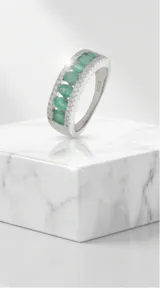 Anillo de plata 925 con diseño medio sin fin, decorado con una hilera central de piedras verdes ovaladas y dos hileras laterales de circonias pavé.