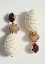 Aros colgantes de diseño estructurado que combinan una cuenta superior redonda y oscura, una cuenta intermedia grisácea y una cuenta inferior ovalada revestida en rafia natural de tono claro, unidas por detalles metálicos dorados.