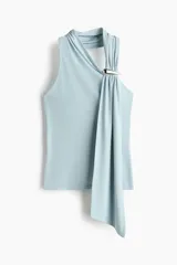 Top halter en punto suave, color celeste claro, con escote asimétrico y tira efecto fular con detalle metálico decorativo y frunces drapeados en un lateral.