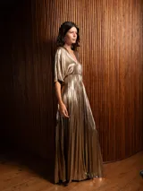 Vestido largo plisado color dorado, con escote en V y mangas cortas tipo murciélago.