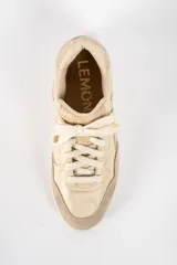 Zapatilla de cuero legítimo en tonos beige, con diseño combinado que incluye paneles de cuero liso, cuero con textura de reptil y detalles de gamuza en la puntera y el talón. Cuenta con cordones al tono y suela de goma.
