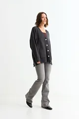 Cardigan de punto color fucsia, con cuello en V, cierre frontal con botones y bolsillos laterales. Presenta un diseño holgado con mangas largas y puños acanalados.