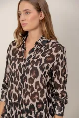Camisa de manga larga con estampado de leopardo, cuello clásico y cierre frontal de botones. Presenta un corte holgado y puños abotonados.