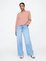 Remera de manga larga color salmón, con cuello redondo y corte holgado.