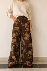 Pantalon wide leg de tiro alto con estampado floral sobre base color marrón. Cuenta con cintura con presillas y cierre frontal.