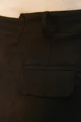 Pantalón de lino color tostado, de tiro alto y corte amplio con perneras rectas. Cuenta con pasacintos, bolsillos laterales y bolsillos traseros con solapa.