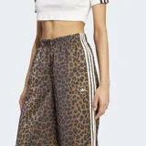 Pantalón Adidas Originals wide leg de satén con estampado animal print, cintura elástica y las icónicas tres tiras blancas a lo largo de los laterales.