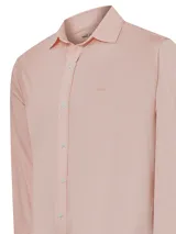 Camisa de manga larga con cuello camisero, confeccionada en tejido técnico flexible y liviano. Presenta un estampado de rayas verticales finas en tono salmón y cierre frontal con botones.