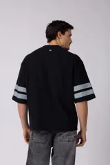 Remerón de corte oversize con cuello redondo y mangas cortas. Presenta un diseño estampado frontal con la palabra 'CONCEPT' y el número '78' en efecto desgastado, además de dos franjas horizontales en las mangas.