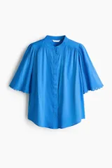 Blusa oversized azul de mezcla de algodón y viscosa, con cuello mao, botonadura frontal y mangas cortas abullonadas con terminación de broderie.