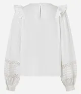 Blusa blanca de tricolina con diseño romántico, cuello redondo, mangas largas abullonadas y detalles de volados verticales en el frente. Presenta aplicaciones de encaje tipo entremedios en el pecho y en las mangas.