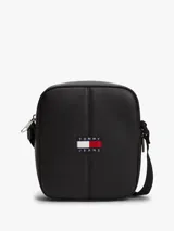 Bandolera reporter de poliuretano negro, con cierre de cremallera, correa ajustable y parche con el logo de Tommy Jeans en la parte delantera.