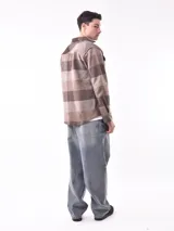 Sobrecamisa a cuadros azul y gris con cuello clásico, cierre frontal con botones, dos bolsillos con solapa abotonada en el pecho y puños abotonados.