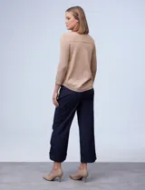 Buzo beige de tejido calado, con escote a la base y mangas tres cuartos.