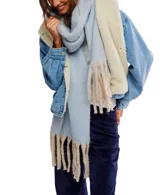 Bufanda manta de tejido suave y peluche, color celeste claro, con flecos largos en los extremos de color beige.